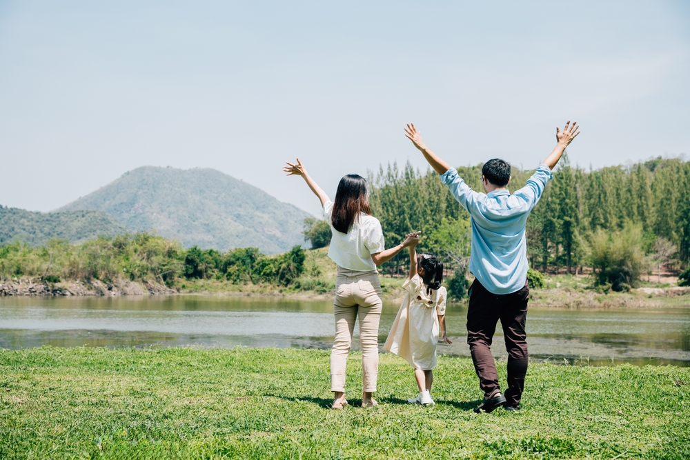Asian,Family,Father,Mother,And,Daughter,Stand,Front,Lake,With